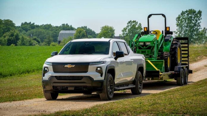 The Chevy Silverado EV effortlessly tows a 10,000-pound John Deere tractor, showcasing its impressive towing capabilities.